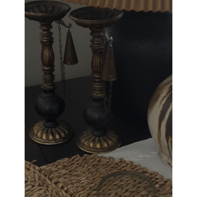 A tall pair of antique fireplace pricket candlesticks dating to circa 1890, with turned wood stems, metal drip cups, and...