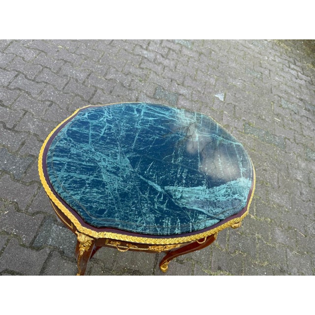 1960s French Louis XVI–Style Center Table – Mahogany & Green Marble This refined 1960s French Louis XVI–style oval table...