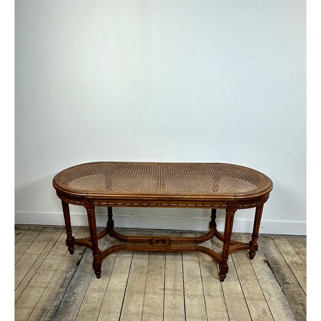 A Louis XVI style "piano bench" in carved walnut with a caned seat, dating from the 1900s/1920s. In very good condition,...