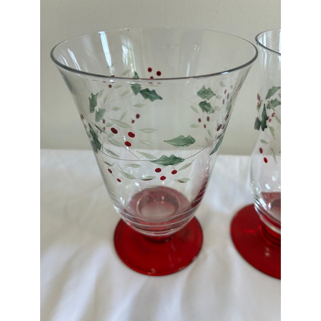 Vintage set of two Pfaltzgraff holiday glasses featuring classic holly berry decoration and striking red stems. These...