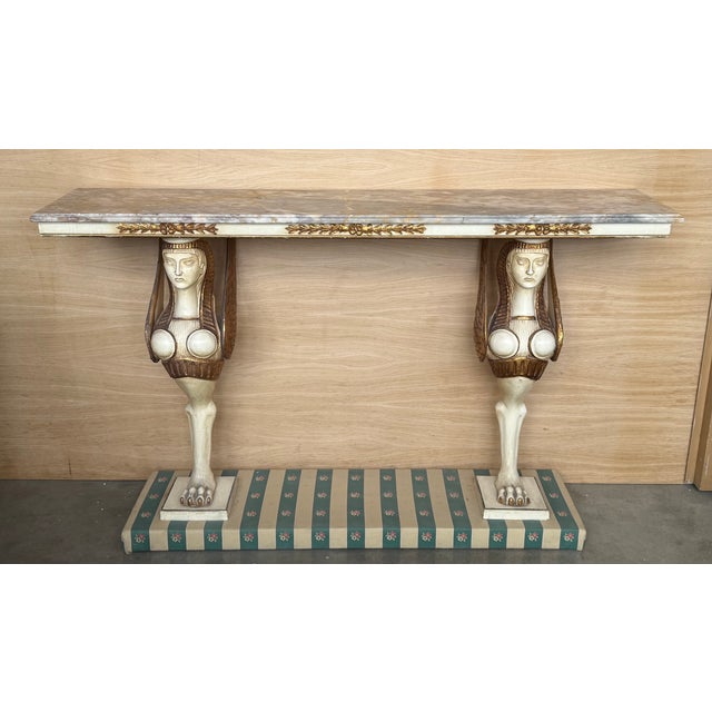 Swedish Empire console table in carved, polychrome and gilt wood, early 20th century. Rectangular marble top in a low...