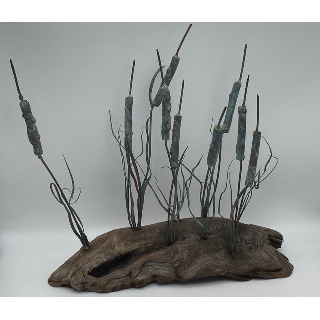 This Curtis Jere-style sculpture captures the beauty of nature through driftwood and delicate, detailed copper cattails....