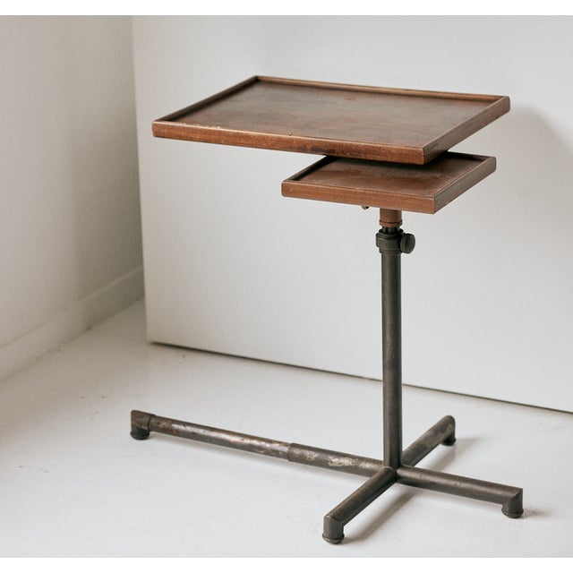 Vintage wooden side table with a tray table top that can double as a workstation. This table sits on a metal base, and one...