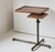 Vintage wooden side table with a tray table top that can double as a workstation. This table sits on a metal base, and one...