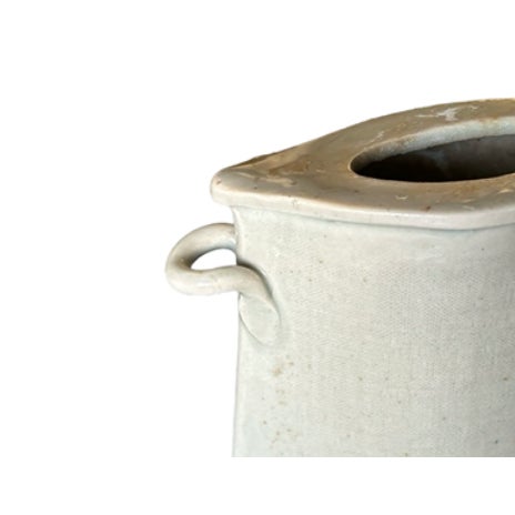 Hand built ceramic vase featuring a unique shape and dual handles. Ideal for modern or rustic decor.