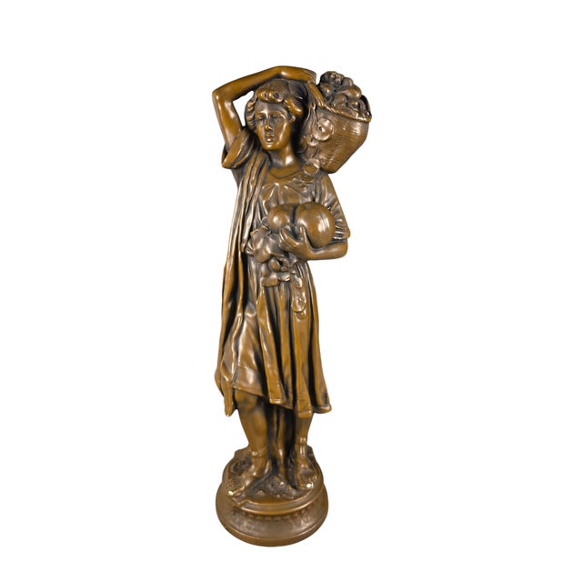 A charming mid-20th-century figurative sculpture by ESCO Products of New York, depicting a young fruit bearer or harvest...