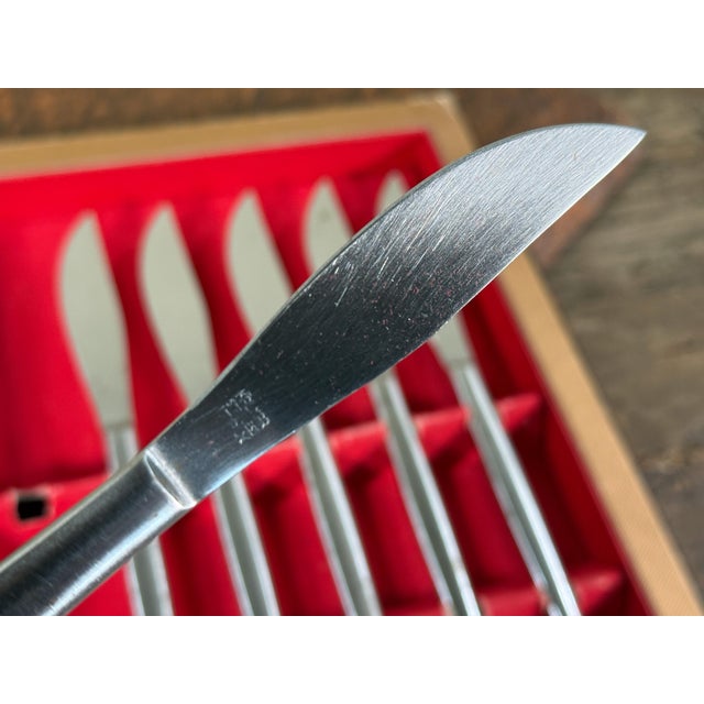 This set of eight stainless steel knives was designed by Kalmar Designs and is presented in the original red velvet lined...