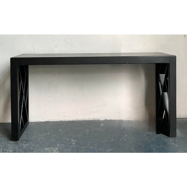 This sleek console table offers a sophisticated blend of minimalist geometry and bold modern structure. Finished in a...