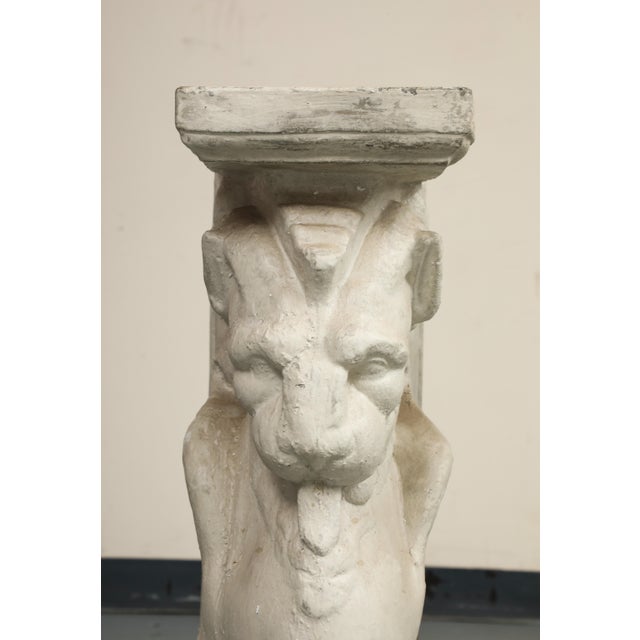 20th century marble-top console table with cast stone pedestals in the forms of winged lions/griffins. The mythological...