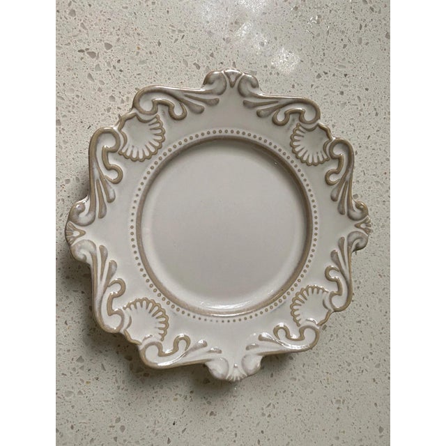 Made of ceramic, the surface features delicate embossed patterns with wavy edges; the light beige glaze paired with a...
