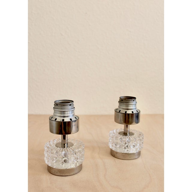 Elegant pair of Italian mid-century table lamps, circa 1960s–1970s, featuring cylindrical pressed glass bases with a...