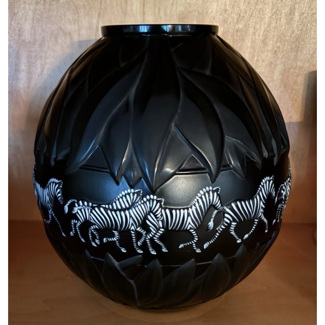 A magnificent and striking Lalique France black crystal vase titled "Tanzania". Sculpted in a dramatic spherical form,...