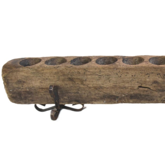 A vintage, rustic 12-hole wooden Mexican sugar mold used as a candle holder and supported by two forged iron stands....