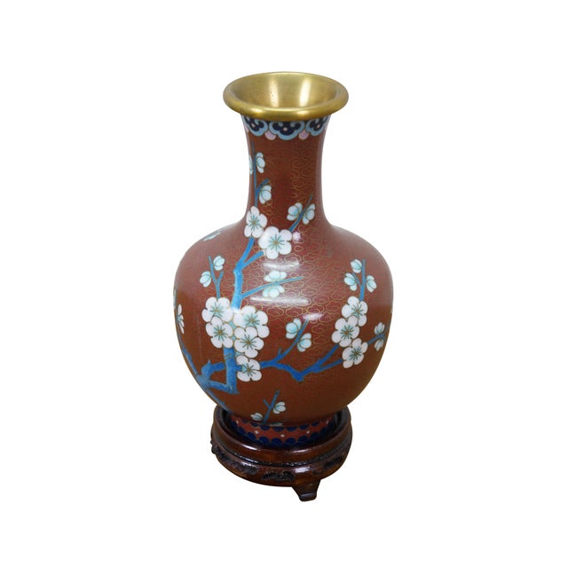 Vintage Chinese brass cloisonné enamel bud vase with a blue and white Cherry Blossom tree motif against a coral red sky....