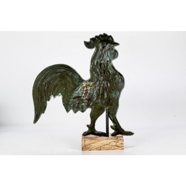 An antique three-dimensional, hollow rooster weathervane figure in profile with a full comb, wattle and sweeping tail...