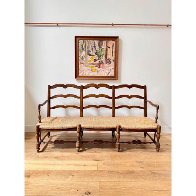 A fabulous 19th century provincial French rush seated bench. In oak and chestnut wood, the shapely ladder back is just...