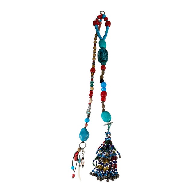 Vintage Tribal Afghan wall hanging adorned with handmade glass beads, coral, turquoise stone, and bronze accents. This...