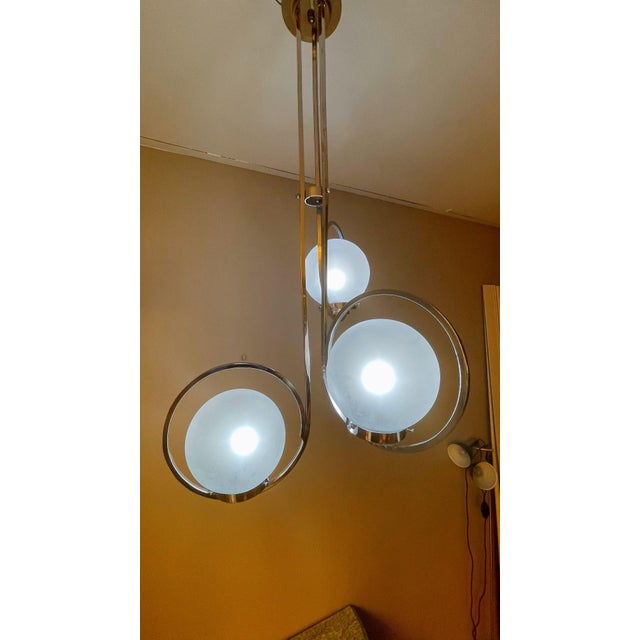 A striking Art Deco silver lamp featuring three spherical glass shades, exuding vintage elegance and geometric style....