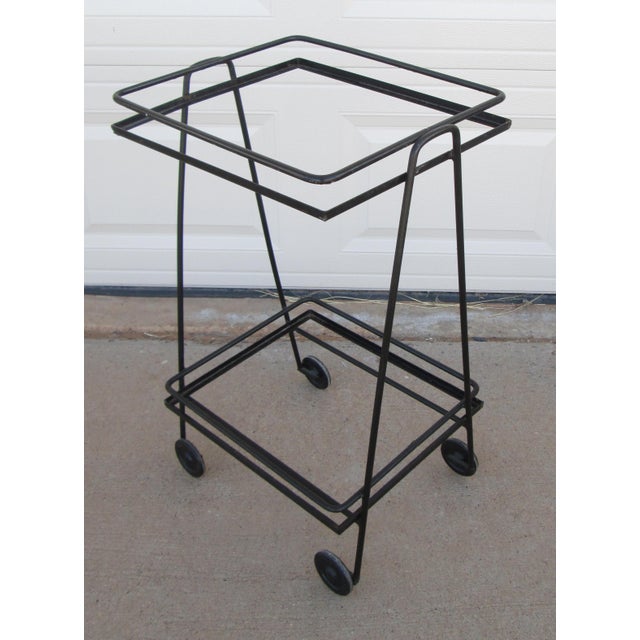 Vintage Mathieu Matégot style mid century modern iron 2 tier rolling bar cart. The cart has 2 removable masonite shelves...