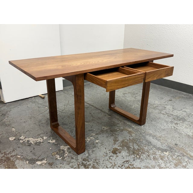 Design Plus Gallery presents a Mid-Century Modern Bespoke Walnut Two Drawer Writing Desk. The broad rectangular top...