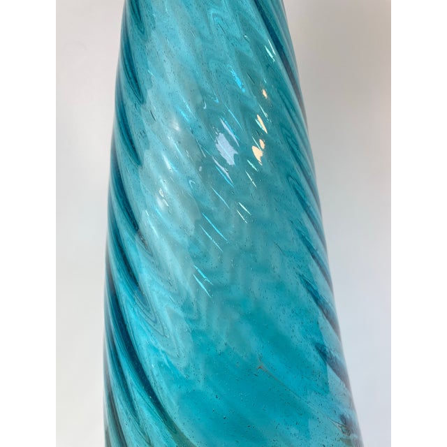 An elegant vintage hand-blown art glass floor bottle featuring a striking optic swirl design in luminous aqua blue glass....