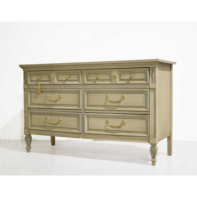This Mid Century French Louis Style Dresser by Dixie is a timeless piece that blends mid-century form with classic...