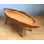 This vintage wooden bowl takes the form of an elongated, boat-like oval, carved with a deep, gently curving well set...