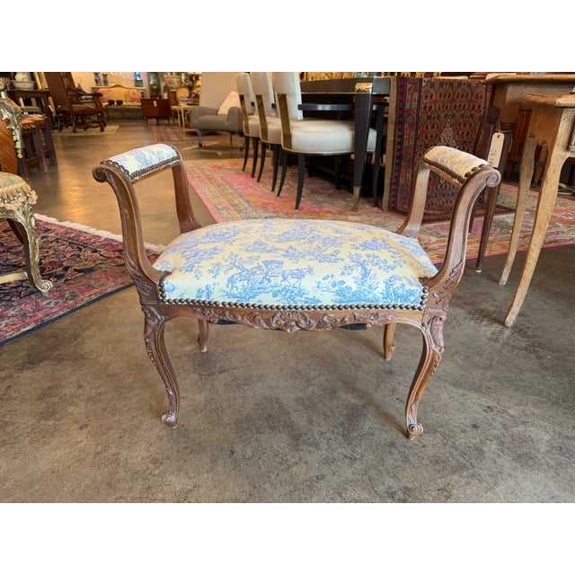 This refined vanity stool features an ornately hand-carved solid wood frame—likely walnut or fruitwood—boasting a...