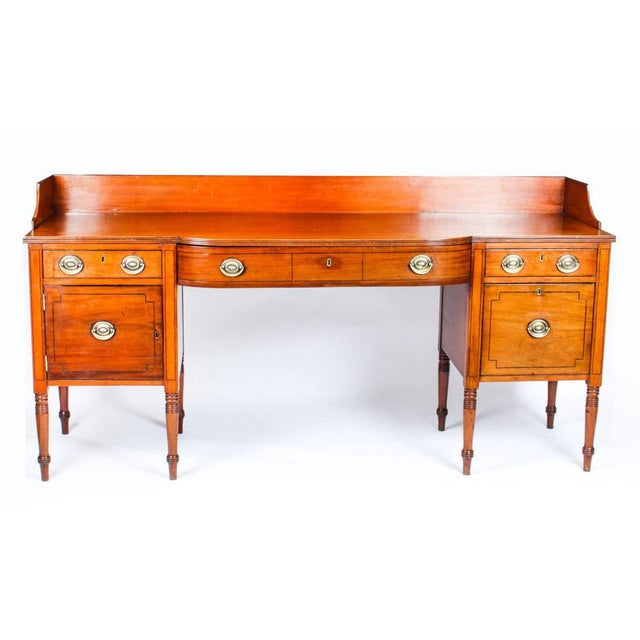 This is a superb antique flame mahogany and ebonized line inlaid bow front George III sideboard, circa 1790 in date. The...