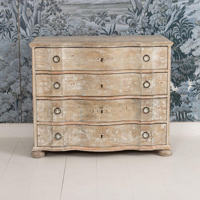 A Danish chest of drawers from the early 19th century in original, natural pine with traces of original paint. Shaped top...