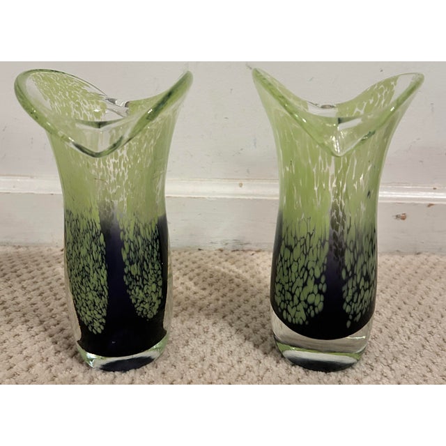 Striking pair of art glass vases featuring a dramatic combination of deep purple and chartreuse green. The sculptural...