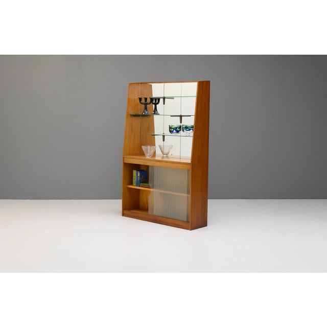 Unusual mid-century mirror backed bookcase, with three glass shelves supported by brass supports and two glazed sliding...