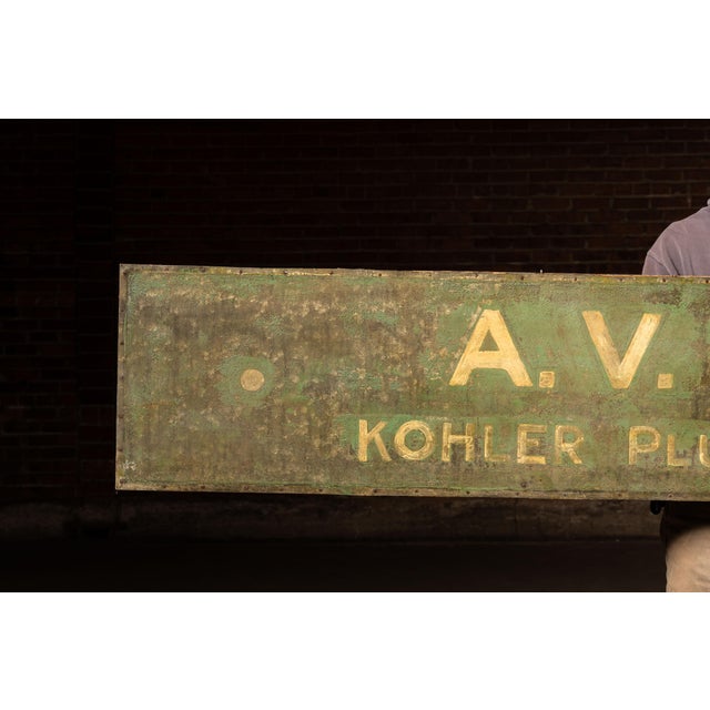 Large hand-painted metal trade storefront sign reading "A.V. PENDL" with "KOHLER PLUMBING AND HEATING" beneath. Long...