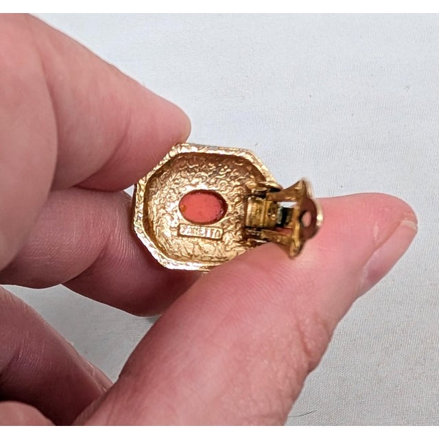 1960s goldtone cabochon faux-coral with round clear rhinestone accent surround octaganal clip earrings. Marked "PANETTA©"...