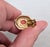1960s goldtone cabochon faux-coral with round clear rhinestone accent surround octaganal clip earrings. Marked "PANETTA©"...