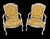 This stunning pair of vintage bergere chairs painted glossy white with custom yellow and white floral linen upholstery are...