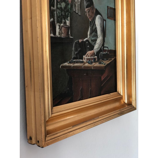 A vintage original oil painting of an elderly craftsman at work in his cottage, dating from 1920. Warm, earthy tones give...
