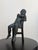 Vintage bronze figural sculpture depicting a young boy asleep in a chair, finished with an intentionally applied verdigris...