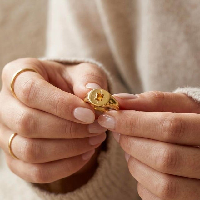 Capture the warmth of the sun and the guidance of the stars. This exquisite Celestial Starburst Signet Ring is a modern...