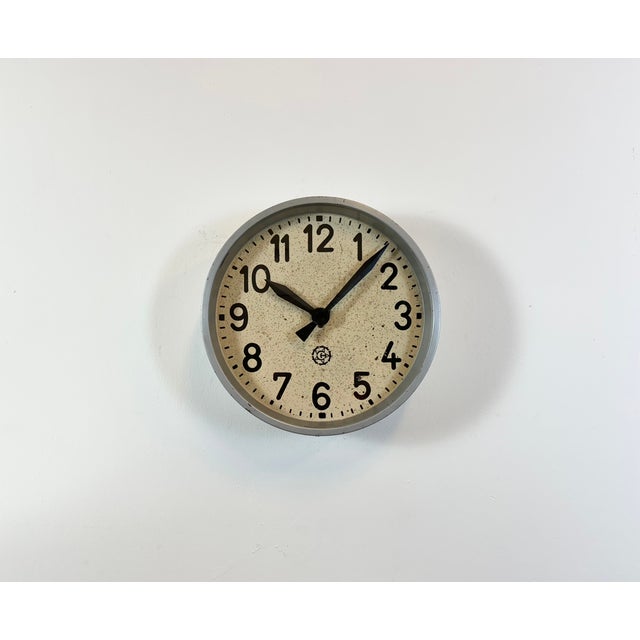 This wall clock was produced by Chronotechna in former Czechoslovakia during the 1950s. It features a grey metal frame, an...