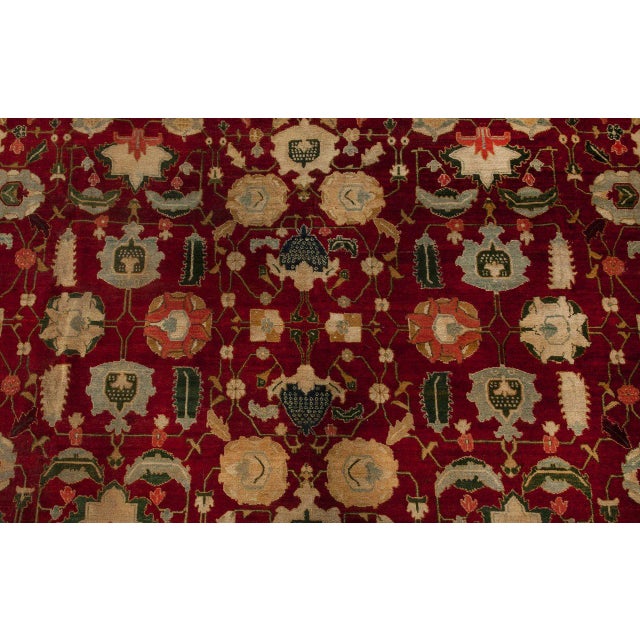 An early 20th century Indian Agra antique rug, the rich red field with a carefully-arranged lattice of palmettes,...