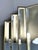 An elegant art deco style wall mirror with a distinctive stepped geometric design, beautifully reflecting the...