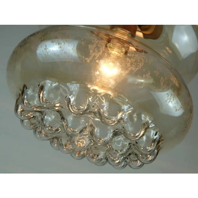 Beautiful 1960s 70s pendant light. The shade is made of slightly amber tinted glass with an etched pattern and a bubble...
