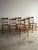 Set of six vintage dining chairs crafted with solid maple frames, spindle backs, and hand-woven rush seats. Warm, time-...