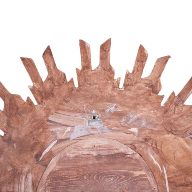 A French sunburst mirror from the late 20th century, hand crafted from wood with a radiant frame of densely arranged...