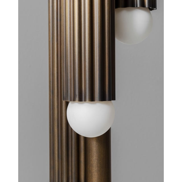 Thirty-two fluted solid brass cylinders are suspended in diamond formation, and a constellation hovering in space. From...