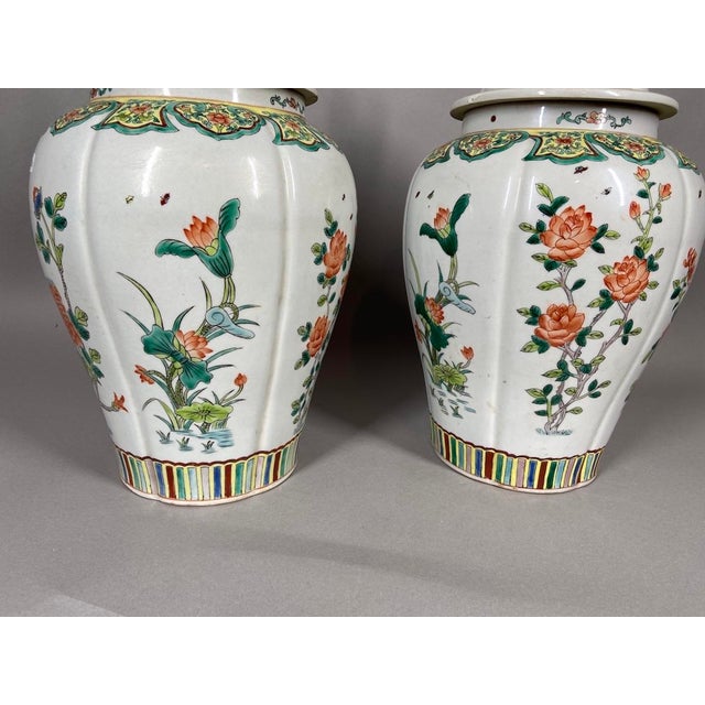 A decorative pair of mid-20th-century Chinese Famille Verte porcelain vases, hand-painted in the traditional Chinese...