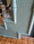 Charming vintage mirror with a soft sage-green finish, faux bamboo detailing, textured crosshatch panels, and decorative...