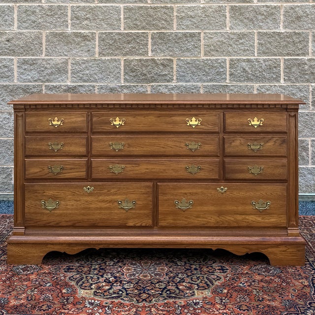 A vintage Pennsylvania House Traditional Chippendale solid oak 8 drawer double dresser having a row of 3 small drawers...