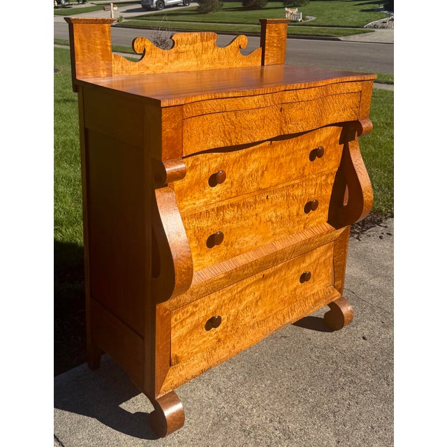 An exceptional and highly figured 19th-century American Empire chest of drawers that beautifully showcases a masterful...